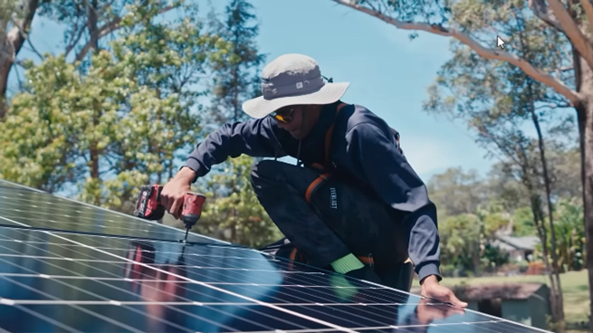 A RESINC member installs solar panels during a system installation.